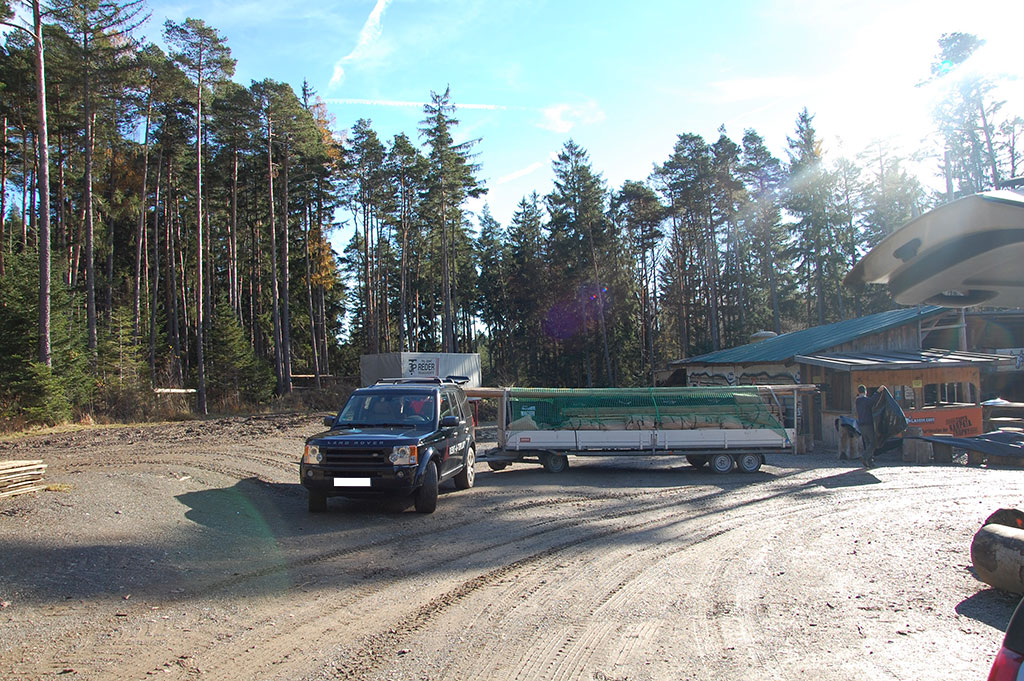 Ein Truck zieht einen offenen Hänger, auf dem ein oder mehrere Alpentipis liegen.